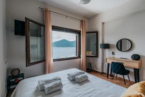 a bedroom with a bed with a window and a desk at Elia Seaside Pteleos in Pteleos
