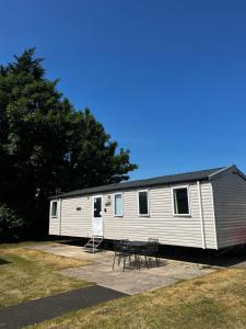 a trailer with a table and chairs in front of it at Aberlady75 in Port Seton