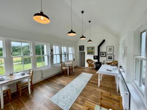 a living room with a table and chairs and windows at Achnacriche B&B in Bonnavoulin