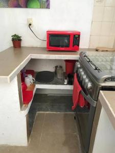 cocina pequeña con fogones y microondas en Departamento Canek 1 en Mérida