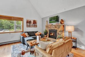 sala de estar con sofá y chimenea en The Sage Chalet in Emerald Lakes, Poconos!, en Long Pond