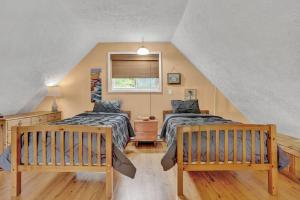 Schlafzimmer im Dachgeschoss mit 2 Betten und einem Fenster in der Unterkunft The Sage Chalet in Emerald Lakes, Poconos! in Long Pond