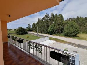 a balcony with a view of a road and trees at Lar de Yago - Casa in Barreiros