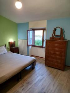 een slaapkamer met een bed, een dressoir en een raam bij La sosta di Fano in Reggello