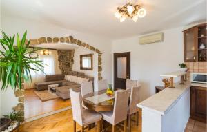 a kitchen and living room with a table and chairs at Beautiful Apartment In Srinjine With 3 Bedrooms, Wifi And Outdoor Swimming Pool in Srinjine