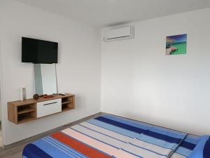 a room with a bed and a flat screen tv at Casa Sonia in Vadu