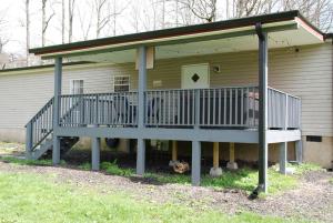 a house with a large deck on the side of it at Cozy Cottage with Full View of the Mountains! in Blue Ridge