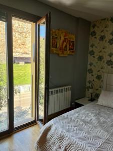 a bedroom with a bed and a sliding glass door at El mirador templario in Ponferrada