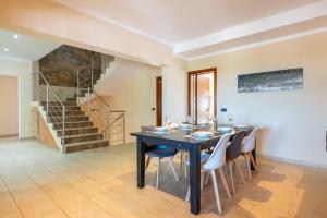 a dining room with a table and chairs and a staircase at Finca Es Figueral in Campos