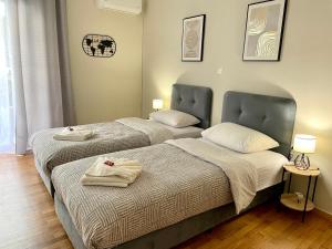 two beds in a hotel room with towels on them at Acropolis Suite greendom in Athens