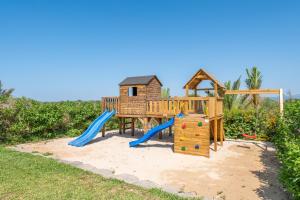 a playground with a slide and a play structure at Finca Es Figueral in Campos
