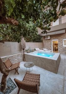 a swimming pool with a chair and a table at Sabbia Mini Pool Suites in Preveza