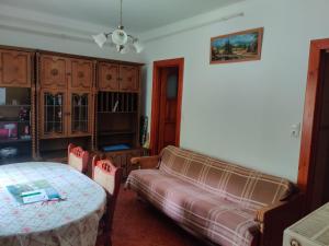 a living room with a table and a couch at Csukavölgyi Apartman in Visegrád