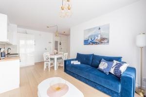 a living room with a blue couch and a table at Posesja Kapitańska Apartament ok 100 m do plaży in Grzybowo