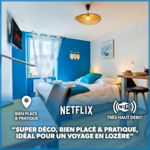 Le Roqueprins - Netflix/Wi-Fi Fibre/Terrasse في Banassac: غرفة نوم زرقاء مع سرير ومكتب