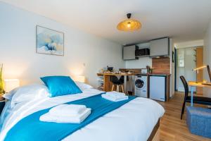 a bedroom with a large bed with towels on it at Le Roqueprins - Netflix/Wi-Fi Fibre/Terrasse in Banassac