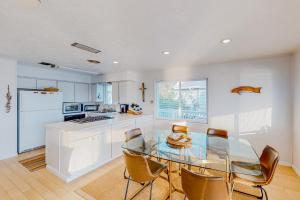 a kitchen with a glass dining table and chairs at Tranquility Base in Galveston