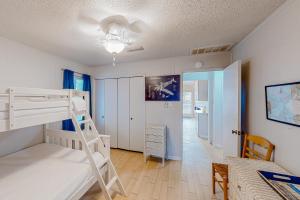 a bedroom with a bunk bed and a desk at Tranquility Base in Galveston