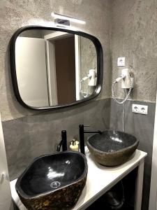 La salle de bains est pourvue d'un lavabo noir et d'un miroir. dans l'établissement Seehotel Losheim, à Losheim