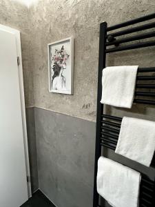 a towel rack in a bathroom with a picture on the wall at Seehotel Losheim in Losheim