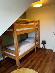 two bunk beds in a room with wooden floors at Seehotel Losheim in Losheim