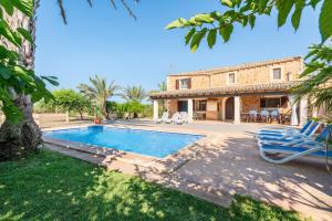 Una vista exterior de una casa con piscina. en Es revolt de sa Barrala, en Ses Covetes