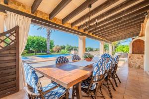 comedor al aire libre con mesa de madera y sillas en Es revolt de sa Barrala, en Ses Covetes