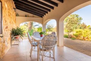 Un patio al aire libre con mesa y sillas. en Es revolt de sa Barrala, en Ses Covetes