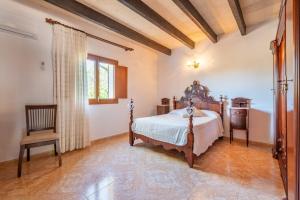 Un dormitorio con una cama y una silla y una ventana. en Es revolt de sa Barrala, en Ses Covetes 17 fotos más