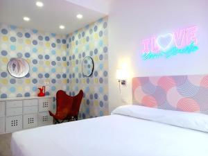 a bedroom with a white bed with a love sign on the wall at Casa Vacanze MARE BOOM in Martinsicuro