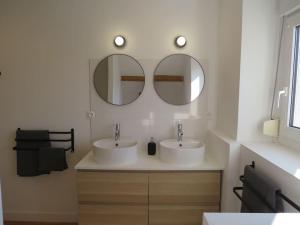 two sinks in a bathroom with two mirrors at Maison - plage à pied in Frehel