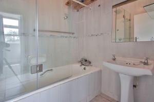 Un baño con bañera, lavabo y ducha. en Breath taking sea views, en Uvongo Beach 22 fotos más