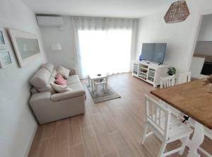 a living room with a couch and a television at Amplio apartamento con piscina al lado de la playa in Platja d'Aro