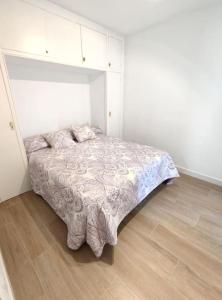 1 dormitorio con 1 cama en una habitación blanca en Amplio apartamento con piscina al lado de la playa, en Platja d'Aro