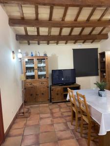 a living room with a table and a television at FINCA MAS GUIXOT relax y natura in Montagut