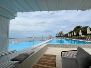 佩特坎內的住宿－Sunny apartman u resortu, Petrčane, apartman za 4, AKCIJA!，一个带沙发和椅子的大型游泳池