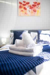 a pile of towels sitting on top of a bed at Stylish Studios with Ensuite, Separate Kitchen, and Prime Location in St Helen in Saint Helens