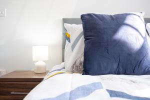 a bed with a blue and white pillow and a table at Stylish Studios with Ensuite, Separate Kitchen, and Prime Location in St Helen in Saint Helens