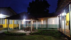 een patio met een tafel en 's nachts een gebouw bij NOVO HOTEL SOURE in Soure