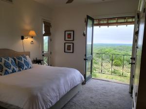 a bedroom with a bed and a sliding glass door at Sage Hill Inn & Spa in Kyle