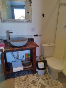 a bathroom with a sink and a toilet and a mirror at Loft Monte Alegre Village in Monte Alegre do Sul