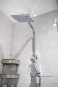 a shower in a bathroom with a sink and a light at Stylish Studios with Ensuite, Separate Kitchen, and Prime Location in St Helen in Saint Helens