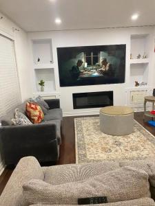 a living room with a couch and a large tv at Aiden Mansion in London