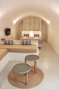 a room with two beds and a table at OUTOPOIA CAVE STUDIOS in Oia +57 photos