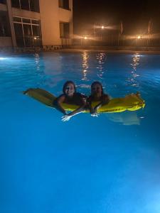 a man and a woman in a swimming pool at night at Prostor Apartments in Obzor