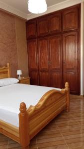 - une chambre avec un grand lit et des placards en bois dans l'établissement luxury apartments, à Assilah