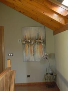 a painting on a wall with a lamp on a table at Casa rural con piscina in Arnoso