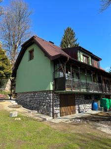 une grande maison avec un mur en pierre dans l'établissement Chata pod javorem, à Frymburk