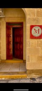 a building with two doors and a sign on it at MJ Farmhouse B&B in Xagħra