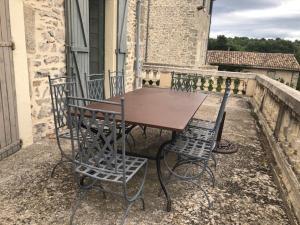 uma mesa de madeira e cadeiras sentadas num pátio em château de Paulignan em Trausse